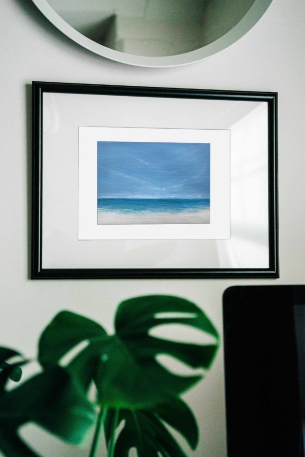 tropical beach painting in frame with monsterra plant